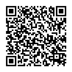 一个身穿黑色皮衣皮裤的女孩子侧身躺在不远处的一块凸起的大石头上二维码生成