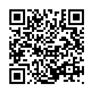 张琛这个大块头男人戴着条围巾正在厨房忙活二维码生成