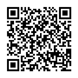 正小心翼翼的将做好的花灯一个一个的挂上边上的架子二维码生成